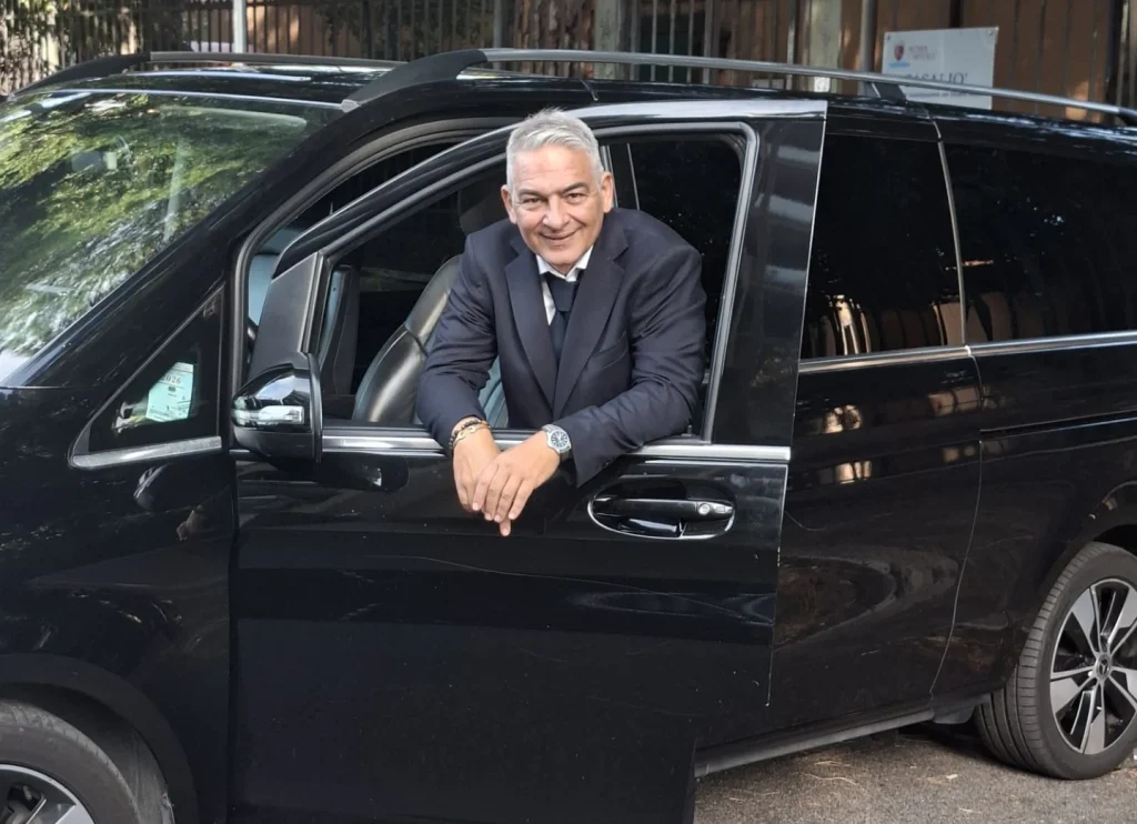 Guido Panetta accanto a un'auto NCC a Roma