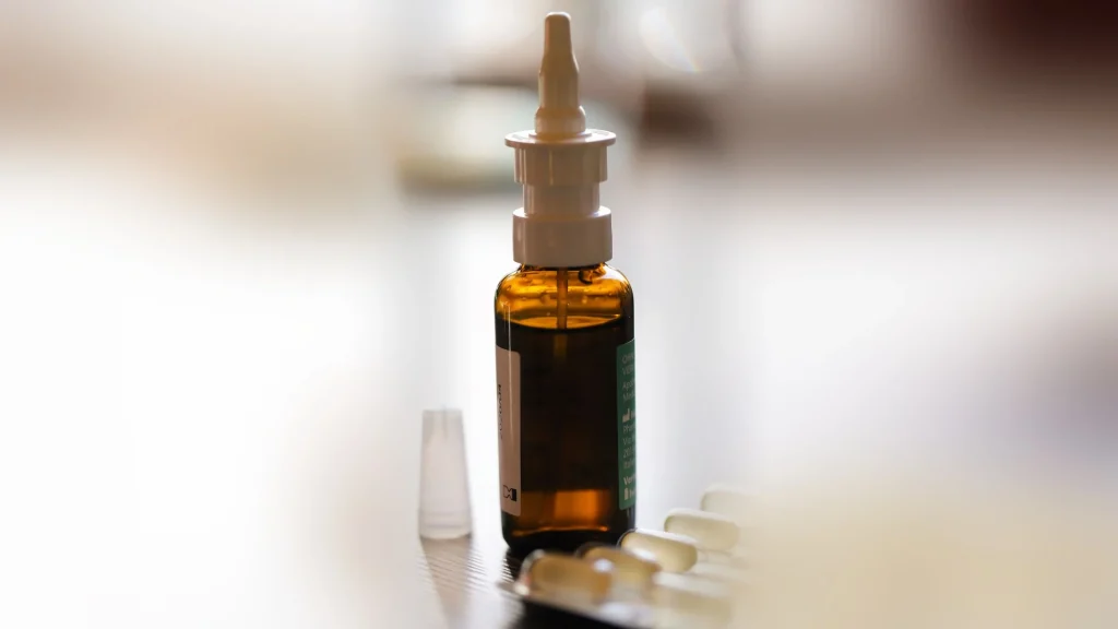 Primo piano di un flacone di spray nasale appoggiato su un tavolo