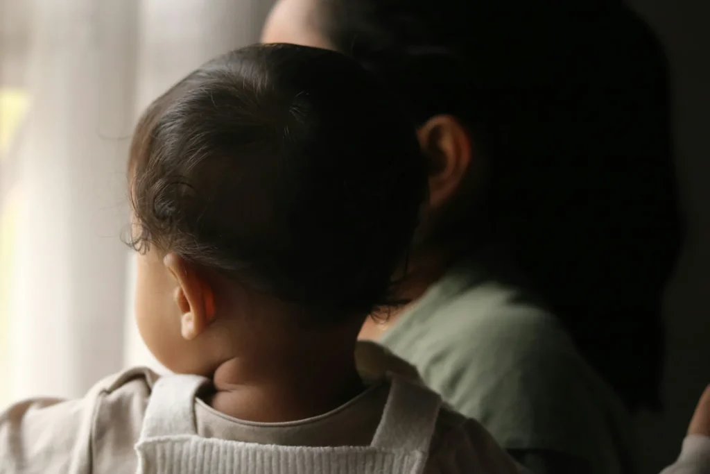 Madre con il proprio bambino davanti a una finestra