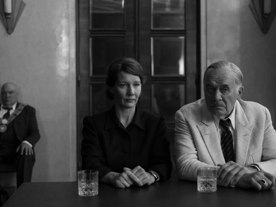 Fatherland, Sandra Hüller e Hanns Zischler seduti a un tavolo in una scena del film