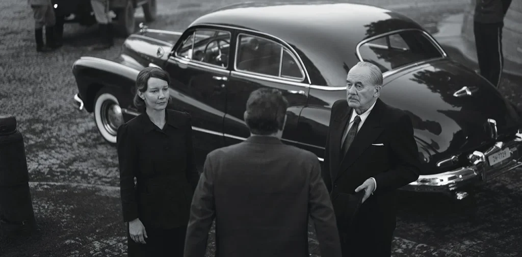 Fatherland, Sandra Hüller e Hanns Zischler seduti a un tavolo in una scena del film