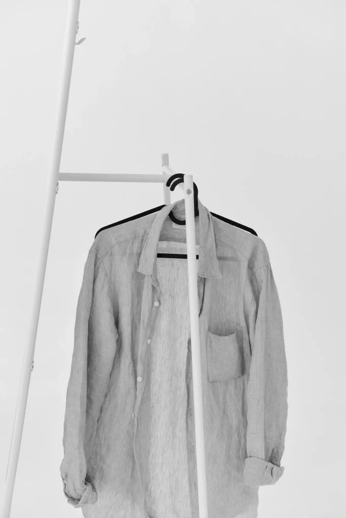 Una camicia appesa in uno spazio minimal, simbolo di un consumo più selettivo
