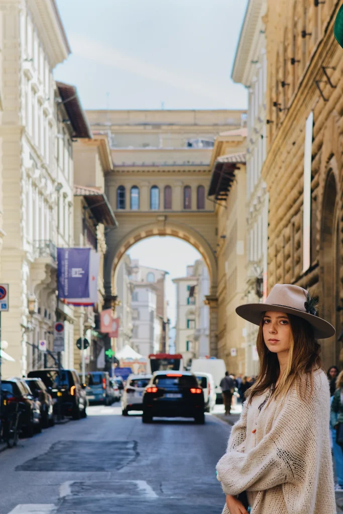 Una giovane donna in piedi in una via affollata di Firenze, vicino all'arco di piazza della Repubblica