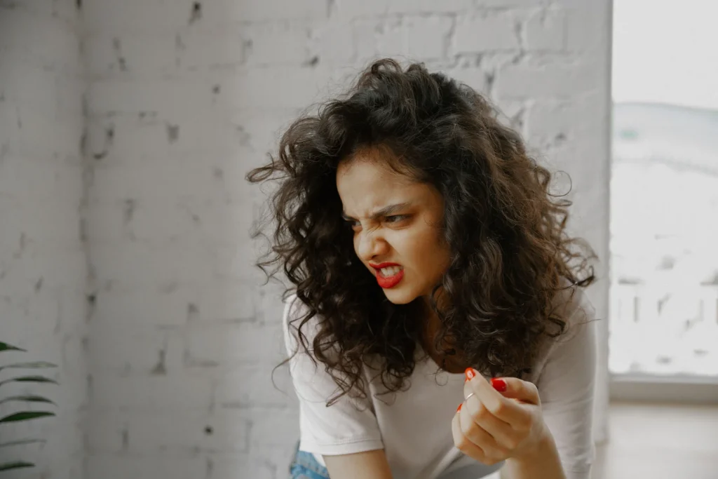 Ciò che vogliamo tenere fuori: il disgusto Una donna con i capelli ricci fa una smorfia di disgusto