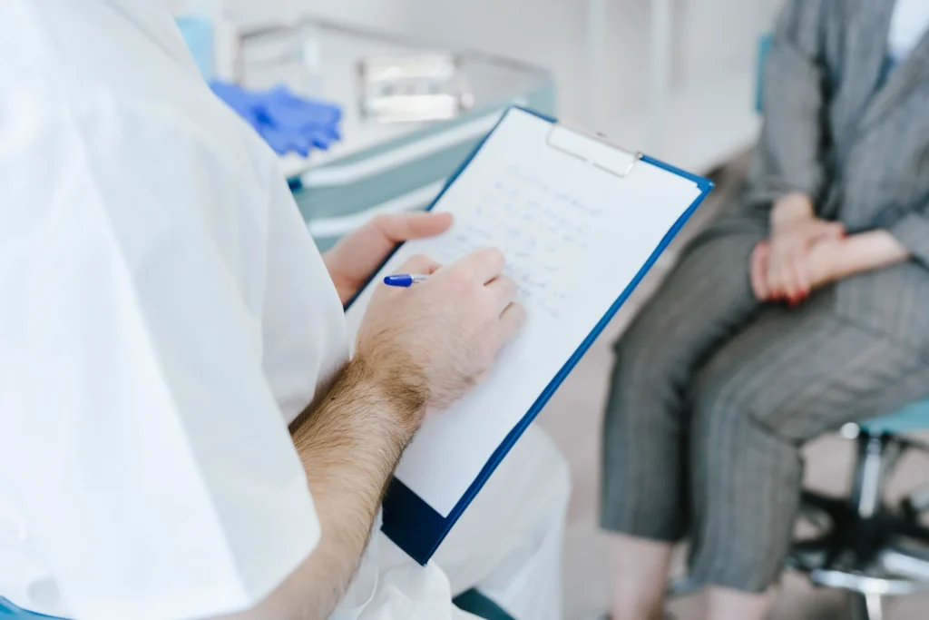Un medico prende appunti durante una visita con un paziente