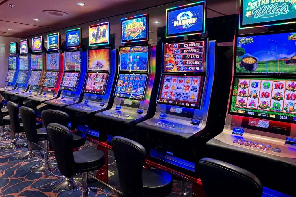 Una fila di slot machine illuminate in una sala giochi